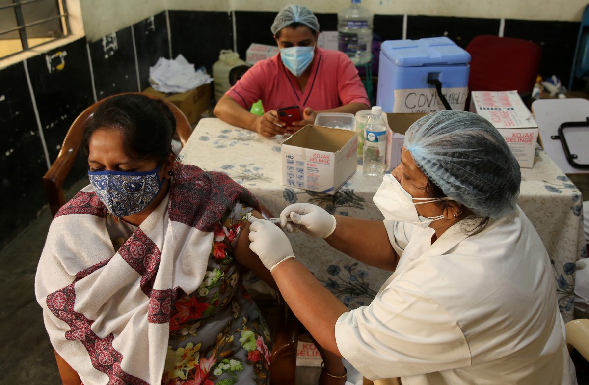 WANITA menerima suntikan vaksin Covid-19 di sebuah pusat pemberian vaksin di India. FOTO EPA