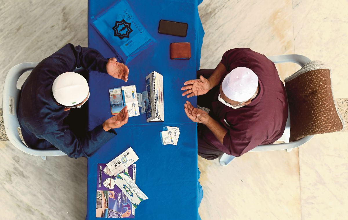 LELAKI membayar zakat fitrah di Masjid Sultan Salahuddin Abdul Aziz Shah, Shah Alam. FOTO fail Bernama 