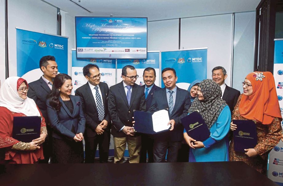 NORHALIM  (lima dari kiri) bersama wakil syarikat penerima dana pada  majlis menandatangani perjanjian antara MTDC dan lapan syarikat penerima dana Program MSI. Turut kelihatan, Timbalan Ketua Setiausaha MOSTI, Prof Madya Dr Ramzah Dambul (empat dari kiri) di Kuala Lumpur, semalam.