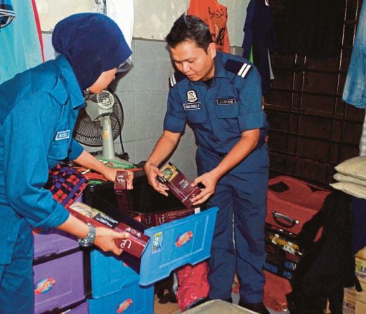 DUA anggota penguat kuasa kastam memeriksa rokok seludup yang dirampas daripada sebuah kedai runcit di  Skudai, Johor Bahru.