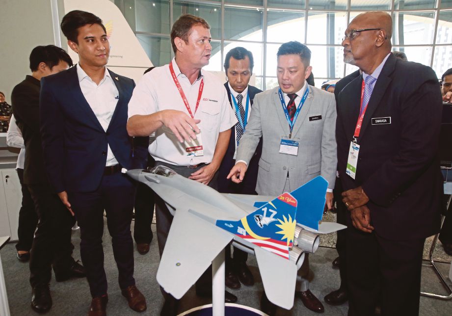 DARELL  (dua dari kanan) mendengar taklimat daripada Ketua Pegawai Eksekutif SME Aerospace, David Fj Davies (dua dari kiri) ketika melihat model jet pejuang negara di ruang pameran MyAero’18 di Kuala Lumpur, semalam.