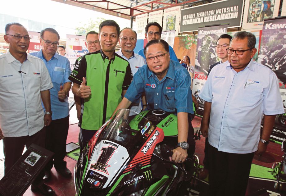  ISMAIL   mencuba motosikal sambil disaksikan  Pengerusi GiatMARA Datuk Azian Othman (lima dari kiri) dan Pengerusi Kawasaki Motor Malaysia Ahmad Faez (empat dari kiri)    pada majlis pertukaran MOA  di GiatMARA Batu.
