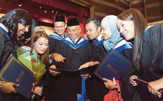 MOHD Saufi Hamzah (tiga dari kanan) menunjukkan Diploma Eksekutif Perhubungan Media dan Komunikasi kepada rakan-rakan beliau di Dewan Tunku Canselor, Universiti Malaya.