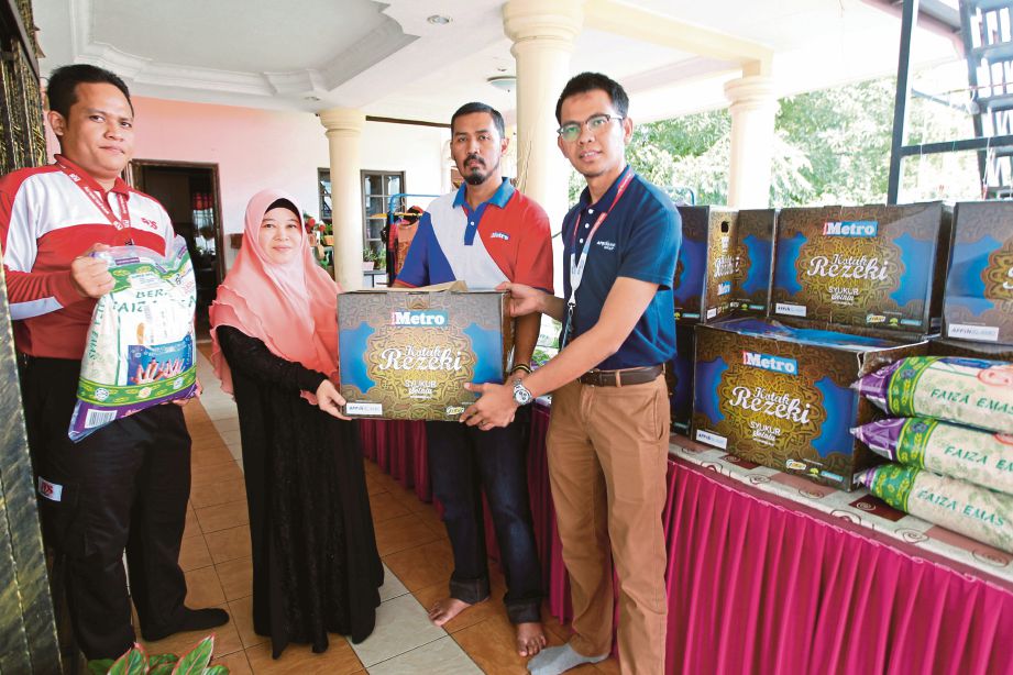  RUDY Fazrunisyam  (dua dari kanan) bersama  Mohd Izwan  (kanan) dan Khairu Anwar  (kiri) menyerahkan Kotak Rezeki kepada Rasyidah  di asrama perempuan Baitul Maghfirah di Bandar Baru Uda, Johor Bahru. 