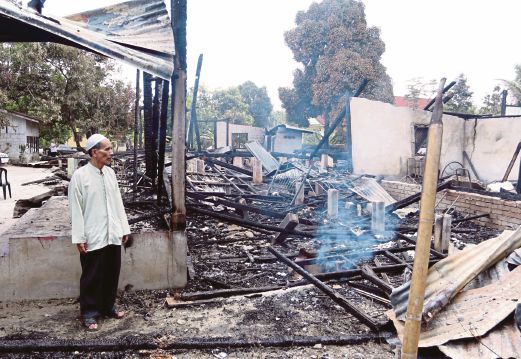 MANGSA kebakaran, Mustapha Omar melihat keadaan rumahnya yang hangus terbakar. 