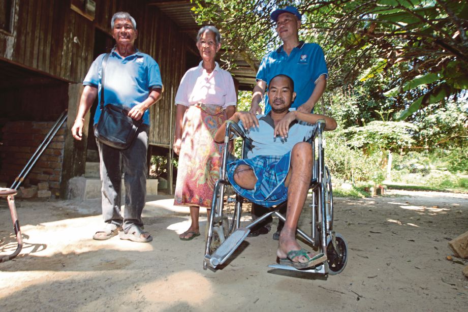 PUI  (kanan) memberi bantuan kerusi roda kepada Eh Chen yang kudung kaki kanan akibat kencing manis sejak lima tahun lalu.