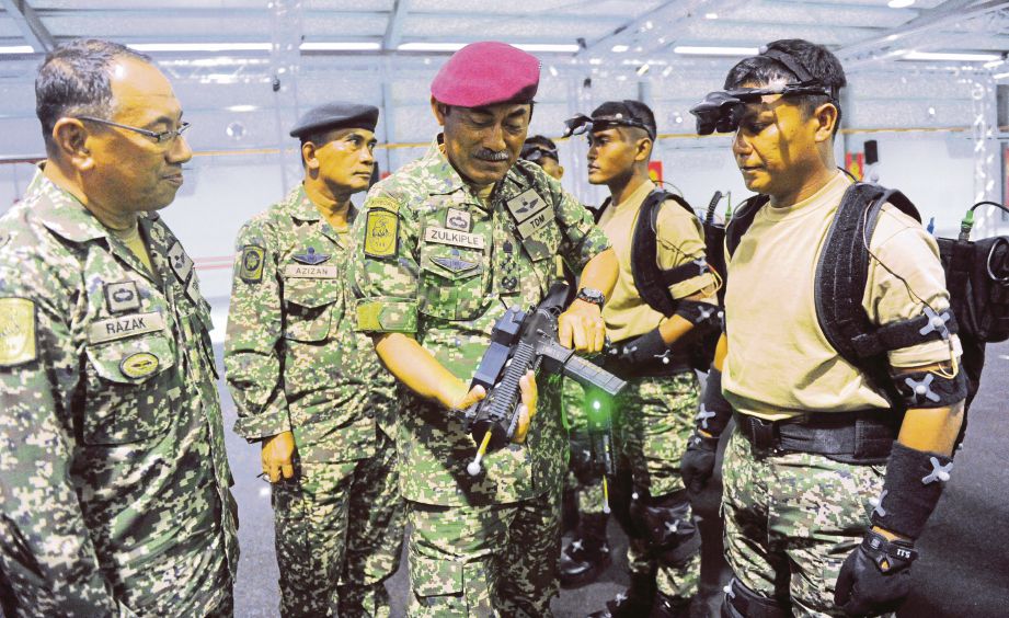 ZULKIPLE (tengah) melihat senjata yang digunakan dalam latihan peperangan Tentera Darat selepas merasmikan sistem VIRTSIM.