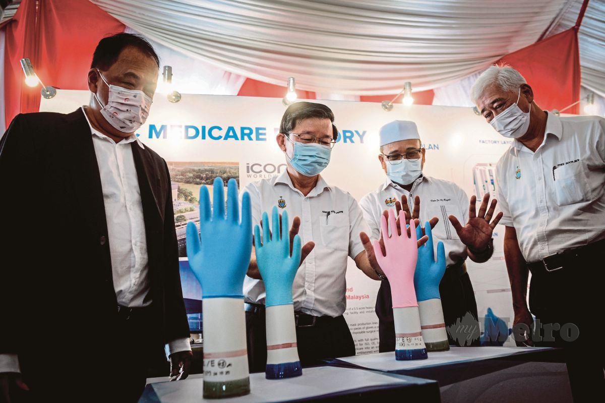 CHOW (dua dari kiri) bersama Tan (kiri) melihat sarung tangan yang dipamerkan pada Majlis Pecah Tanah Iconic Medicare Sdn Bhd.  
