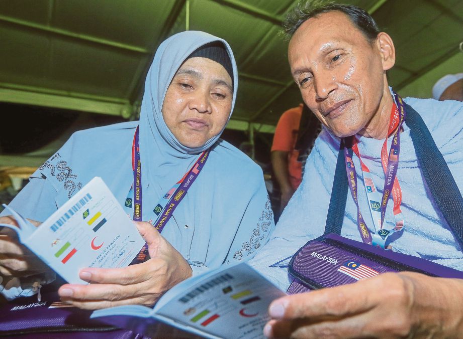 Abdul Rahman dan isteri, Norhayati melihat  buku rekod kesihatan mereka.