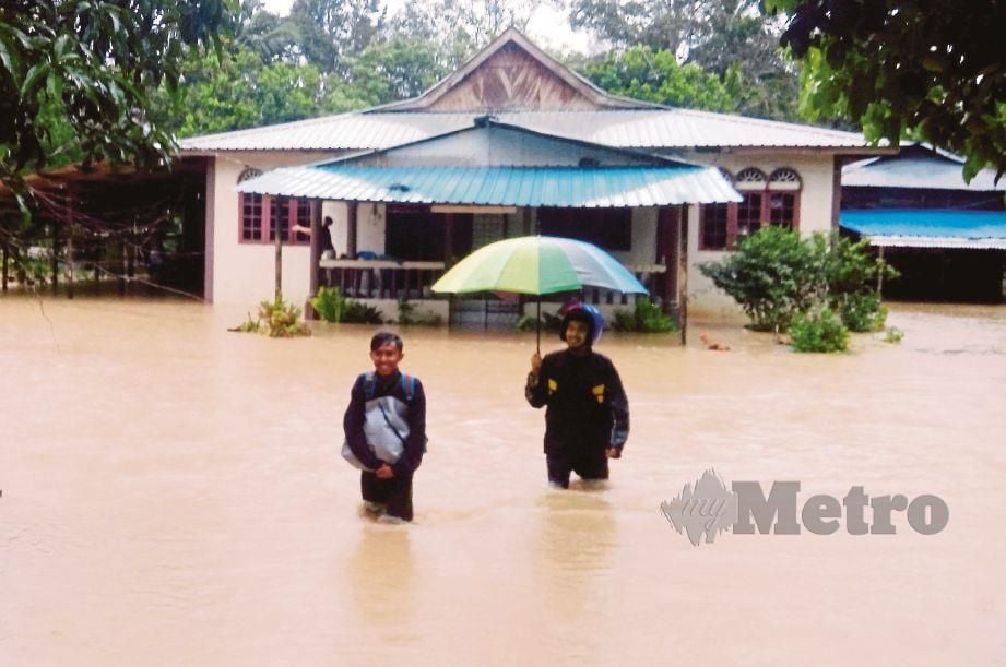 PENDUDUK kampung mula  berpindah selepas kediaman dinaiki air di Kampung Melayu Mardi, Kluang. 