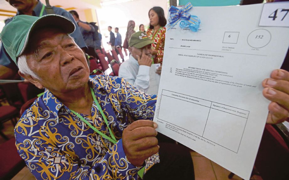 MIDOL Masir menunjukkan geran tanah selepas Majlis Penyampaian Surat Hak Milik Tanah sempena Pilihan Raya Kecil DUN Tanjong Datu. 