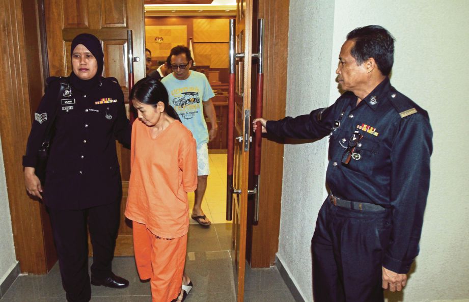 GOH   (depan) dan Chun diiring anggota polis selepas didakwa di Mahkamah Sesyen  Kuantan, semalam.