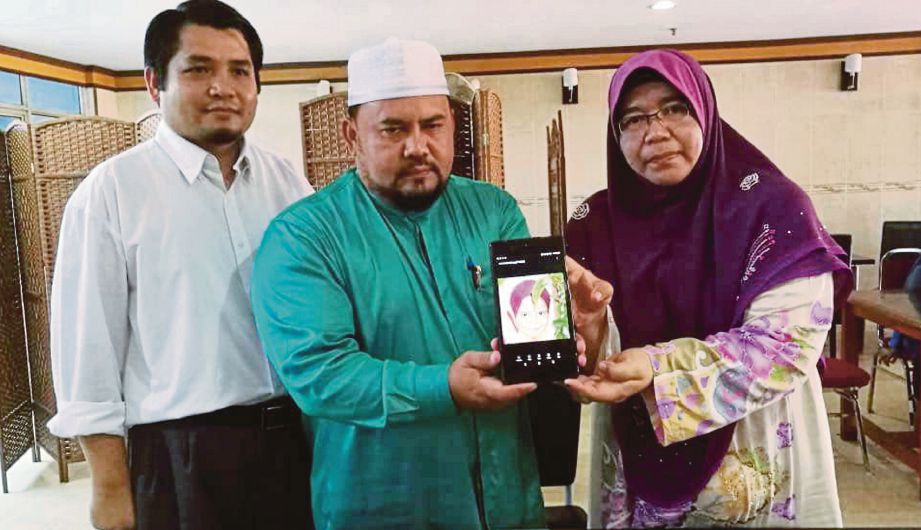 MUHAMAD Sardi  (tengah) dan isteri, Fadilah bersama peguam  menunjukkan gambar anaknya, Ulya Insyirah yang meninggal dunia ketika mendapatkan rawatan di hospital.