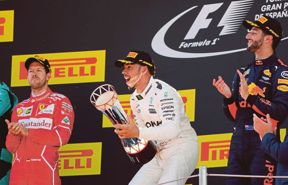 HAMILTON (tengah) menjulang trofi GP Sepanyol.