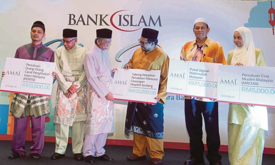SAMSUDIN (tiga dari kiri) menyerahkan sumbangan sempena Majlis Iftar Perdana Bank Islam, semalam.