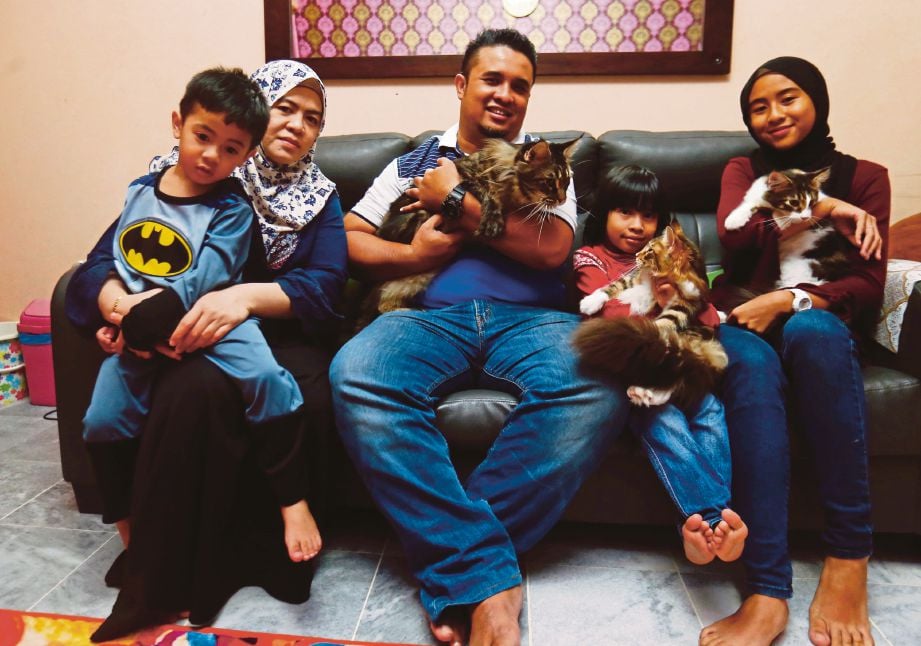 MOHD Badrizam (tengah) bersama isteri dan anak  serta   kucing mereka. 