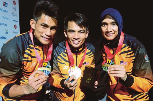 PESILAT negara (dari kiri) Mohd Al Jufferi Jamari, Muhammad Faizul M Nasir dan Siti Rajmah Mohamed Nasir mempamerkan pingat dimenangi pada Sukan SEA 2015. 