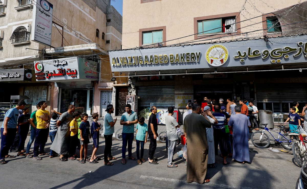 PENDUDUK Palestin di Khan Yunis beratur untuk membeli roti yang semakin kehabisan bekalan akibat peperangan yang berlarutan lapan hari. FOTO Reuters.
