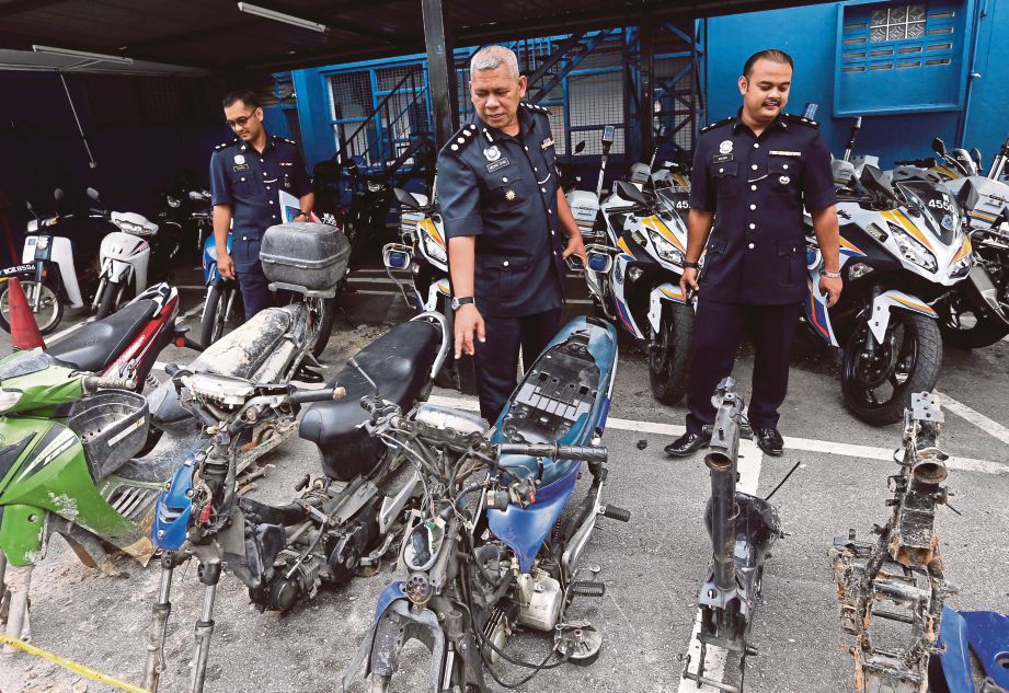 Mohd Zaini  (tengah) bersama pegawainya   menunjukkan  rangka motosikal curi  di IPD Petaling Jaya, semalam.