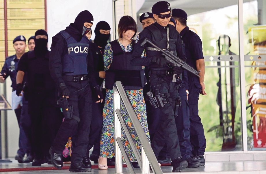 DOAN dikawal anggota polis semasa dibawa keluar dari Mahkamah Tinggi Shah Alam.