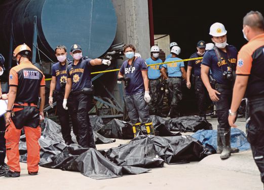 PASUKAN forensik polis membawa keluar mayat yang rentung dalam kebakaran kilang selipar, kelmarin.