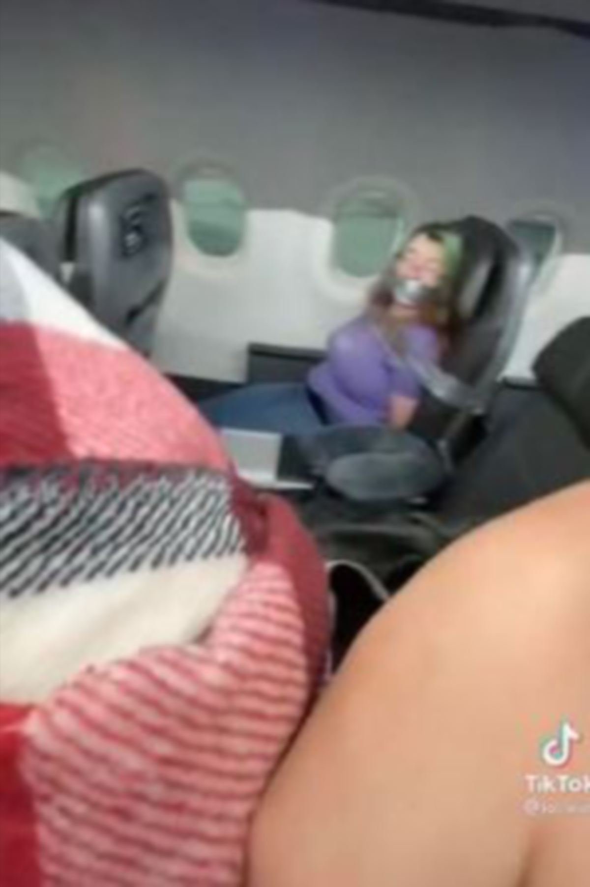 PENUMPANG wanita yang membuat kacau dalam pesawat diikat. FOTO TikTok