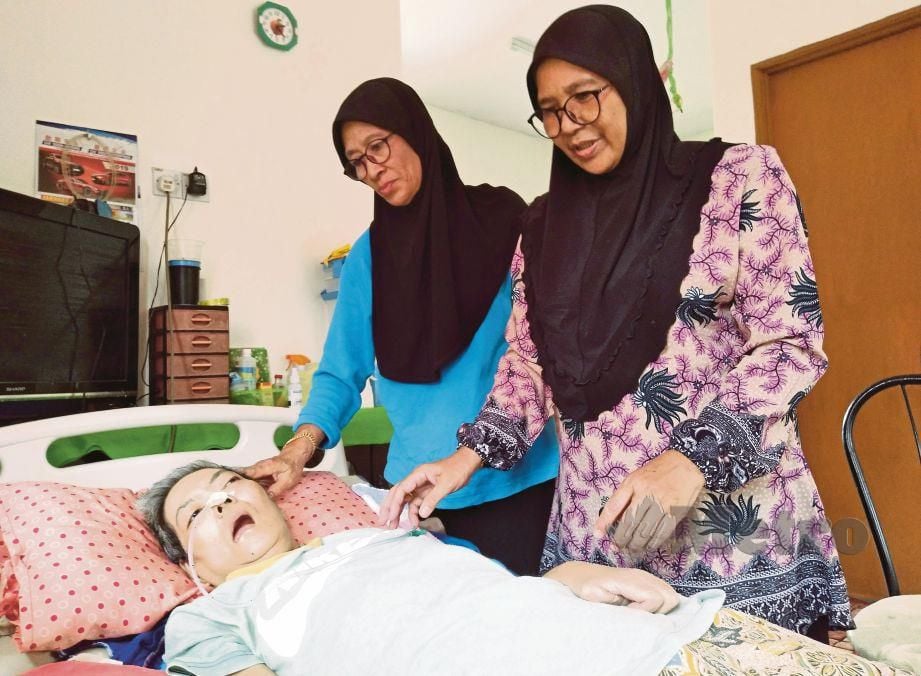 SITI Asiah (kanan) menjaga kakaknya, Siti Fatimah lumpuh seluruh badan sejak dua bulan lalu. 