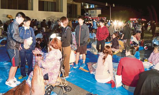 PENDUDUK di bandar Mashiki berkumpul di depan bangunan pejabat majlis perbandaran selepas gegaran menumbangkan beberapa bangunan di wilayah Kumamoto, semalam.  