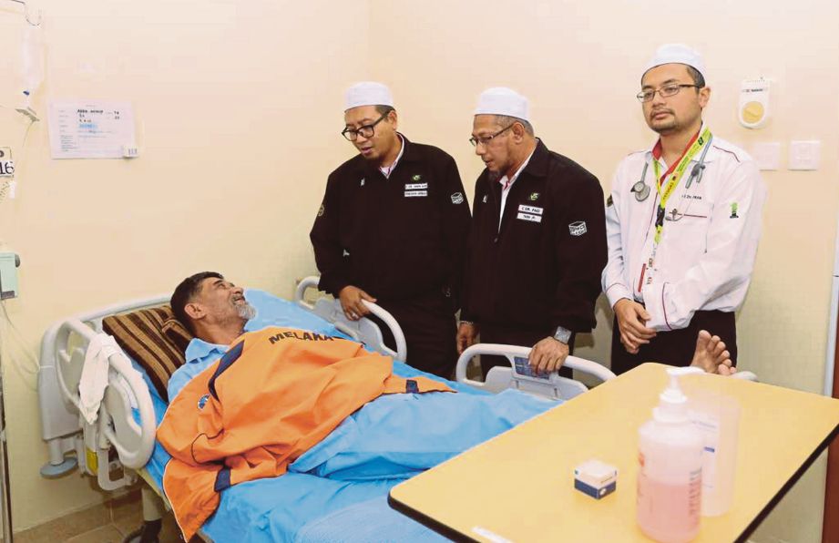 DR Mohammad Faid  (tengah) berbual dengan   pesakit yang dirawat di Pusat Rawatan Syisyah sambil diperhatikan   Dr Amin  (kiri) dan doktor bertugas. 