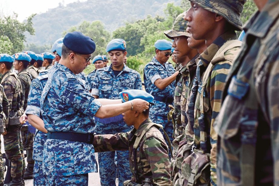 ABDUL Mutalib (kiri) memakaikan beret biru kepada anggota TUDM Malaysia lulus ujian asas komando.