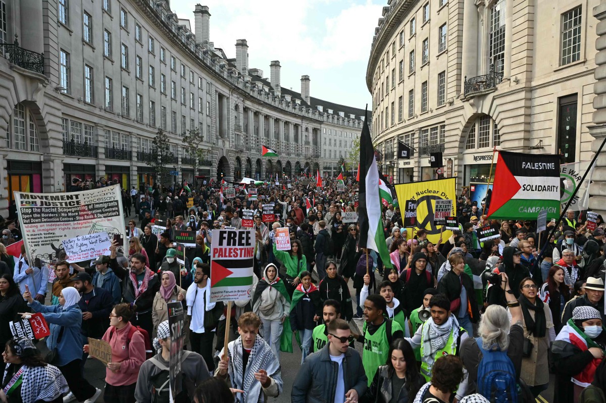 PENDUDUK berarak di Regent Street bersama plakad menyuarakan solidariti terhadap rakyat Palestin di London, semalam. FOTO AFP.