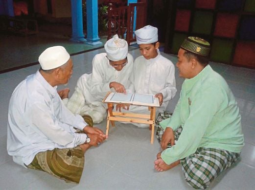 AHMAD Amir (dua dari kanan) dan Mohd Adib  bermuzakarah mengenai al-Quran.