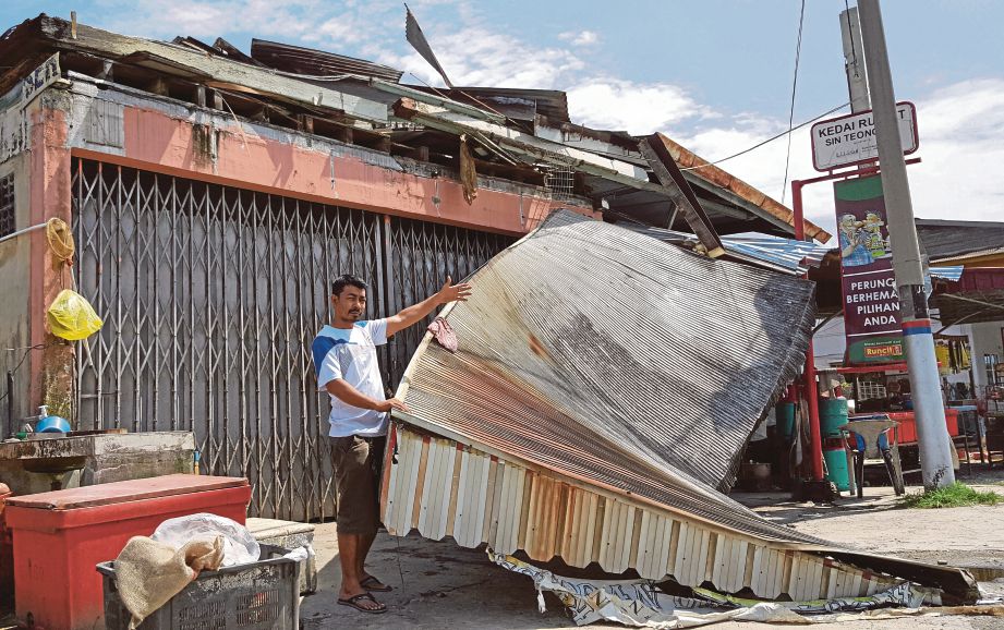 ANUAR menunjukkan   bumbung kedainya yang diterbangkan ribut  di Jalan Changkat Asa. 
