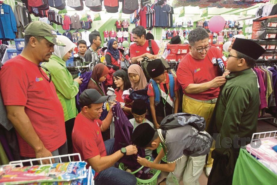 SUKARELAWAN Harian Metro membantu anak yatim memilih pakaian Aidilfitri di Pusat Pakaian Hari-Hari di Tanjung Malim.