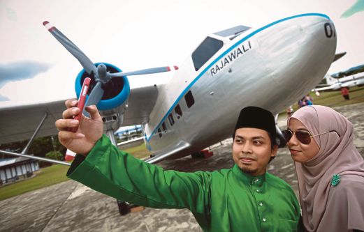 Mohd Amirul Helmi Md Ayob, 24,  bersama Nurul Amlaiah Asparudin, 22,  bergambar di hadapan pesawat Rajawali.