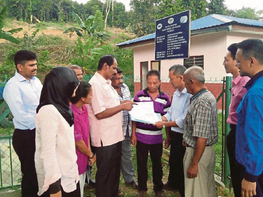   Manickam (tengah) melihat pelan projek bekalan elektrik luar bandar di Kampung Orang Asli Jeram Padang.