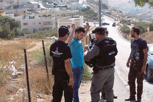 POLIS sempadan Israel memeriksa seorang pemandu Palestin di Baitulmaqdis Timur, semalam.