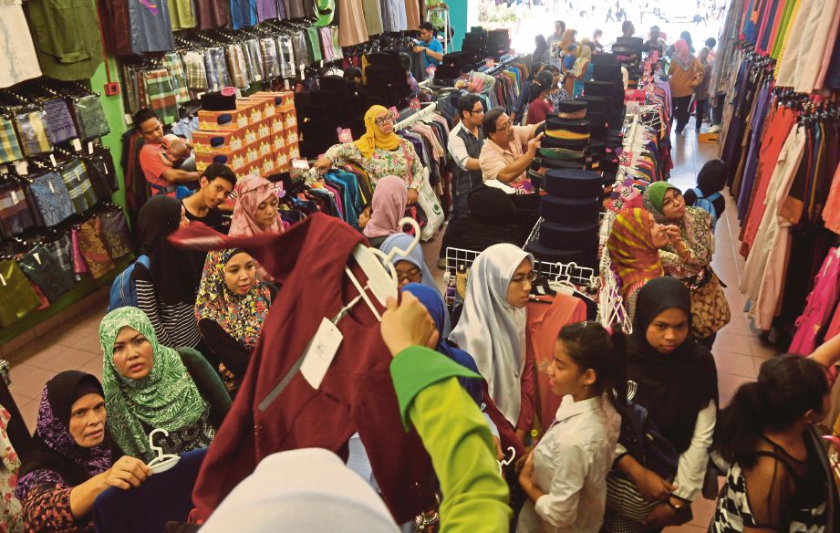ORANG ramai mengambil peluang membeli  barangan persiapan raya  di Jalan Tuanku Abdul Rahman.  