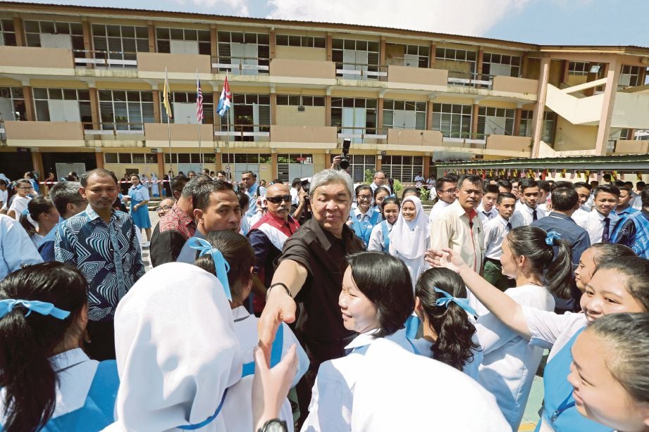 AHMAD Zahid bersalam dengan pelajar ketika hadir untuk lawatan kerja ke SMK Rosli Dhoby, Sibu.