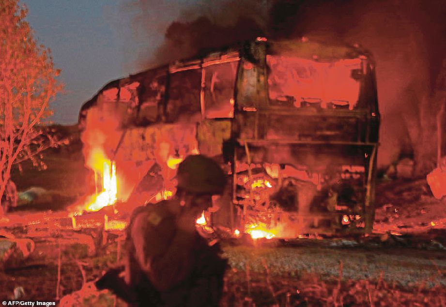 ASKAR Israel melihat sebuah bas yang terbakar akibat terkena serangan roket oleh pergerakan Hamas. - AFP