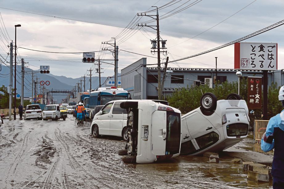 KENDERAAN terbalik  selepas dilanda taufan Hagibis di Nagano, Jepun. FOTO AFP