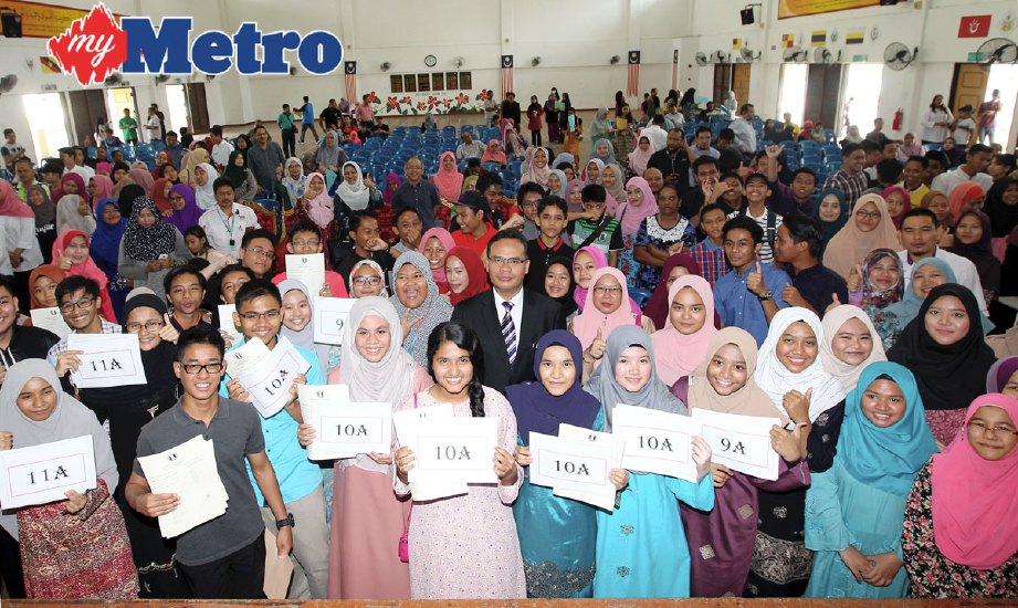 Pengetua SMK Putrajaya Presint 16 (1), Ab Aziz Mamat bergambar bersama pelajar yang mengambil keputusan Pentaksiran Tingkatan 3 (PT3) hari ini. FOTO Ahmad Irham Mohd Noor