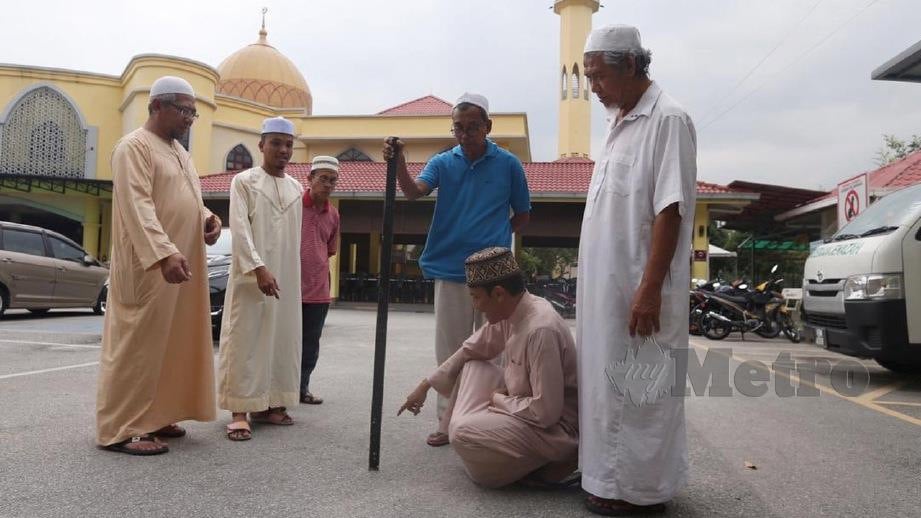 IMAM 2, Muhammad Al Nawawi Borhan (dua kanan) bersama jemaah masjid memeriksa arah kiblat menggunakan kayu yang dipacak tegak pada 5:28 petang di perkarangan Masjid Saidina Umar Al Khattab, Bukit Damansara. FOTO Zunnur Al Shafiq