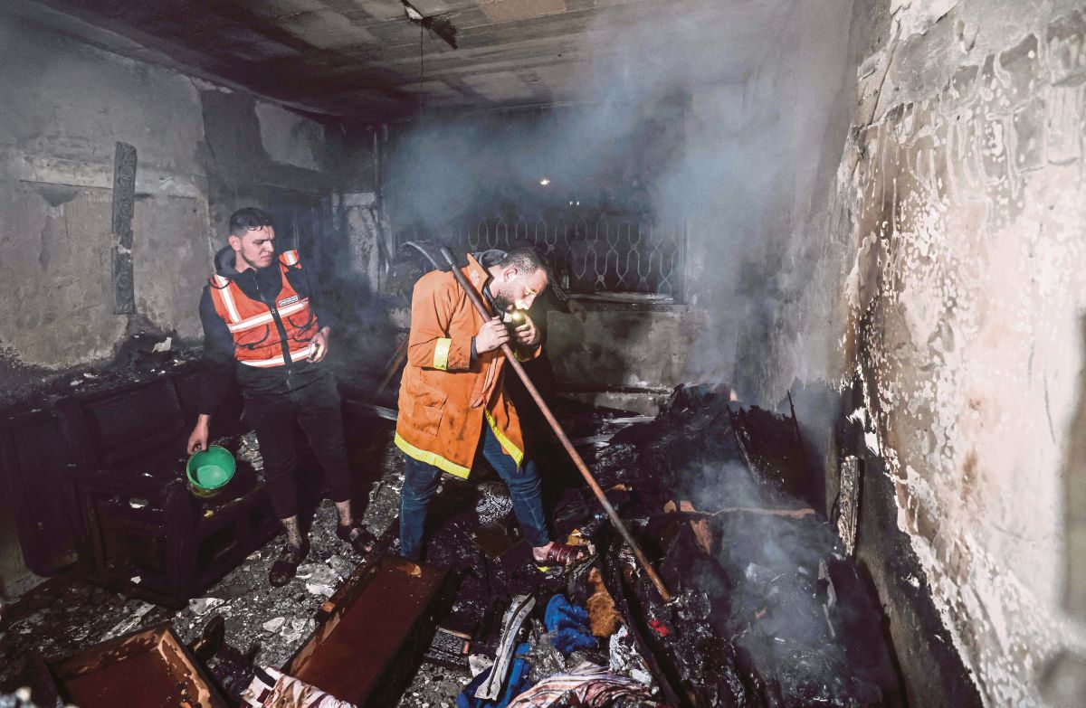BOMBA Palestin memadam kebakaran di bangunan berkenaan di kem pelarian Jabalia. FOTO AFP