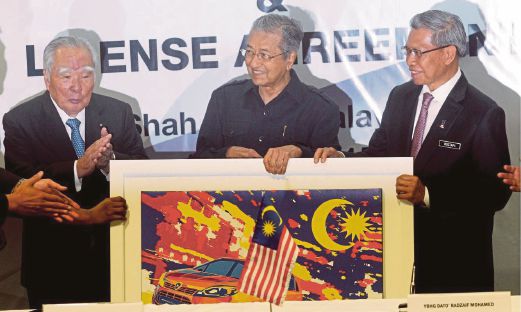DR Mahathir  (tengah) bersama Mustapa  (kanan) dan  Osamu selepas majlis menandatangani perjanjian persefahaman di Shah Alam, semalam. 