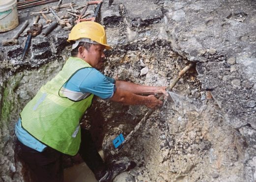 PEKERJA kontraktor SYABAS memotong paip haram yang dipasang pihak restoran di  Teluk Pulai, Klang.