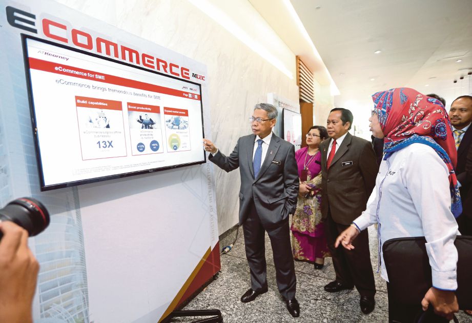 MUSTAPA   melihat skrin informasi ECOMMERCE pada mesyuarat NeCC di Menara MITI, Kuala Lumpur, semalam.