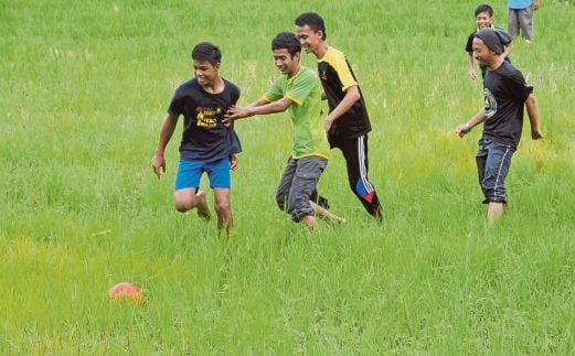 PESERTA bermain bola sepak sawah di Kampung Padang Lebar, Terachi, semalam.