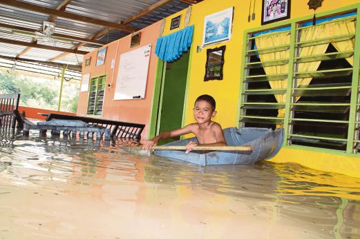  Muhammad Nashrul Iman Moktar, 11, bermain air berikutan banjir yang melanda rumahnya  di Belimbing Dalam, Melaka.