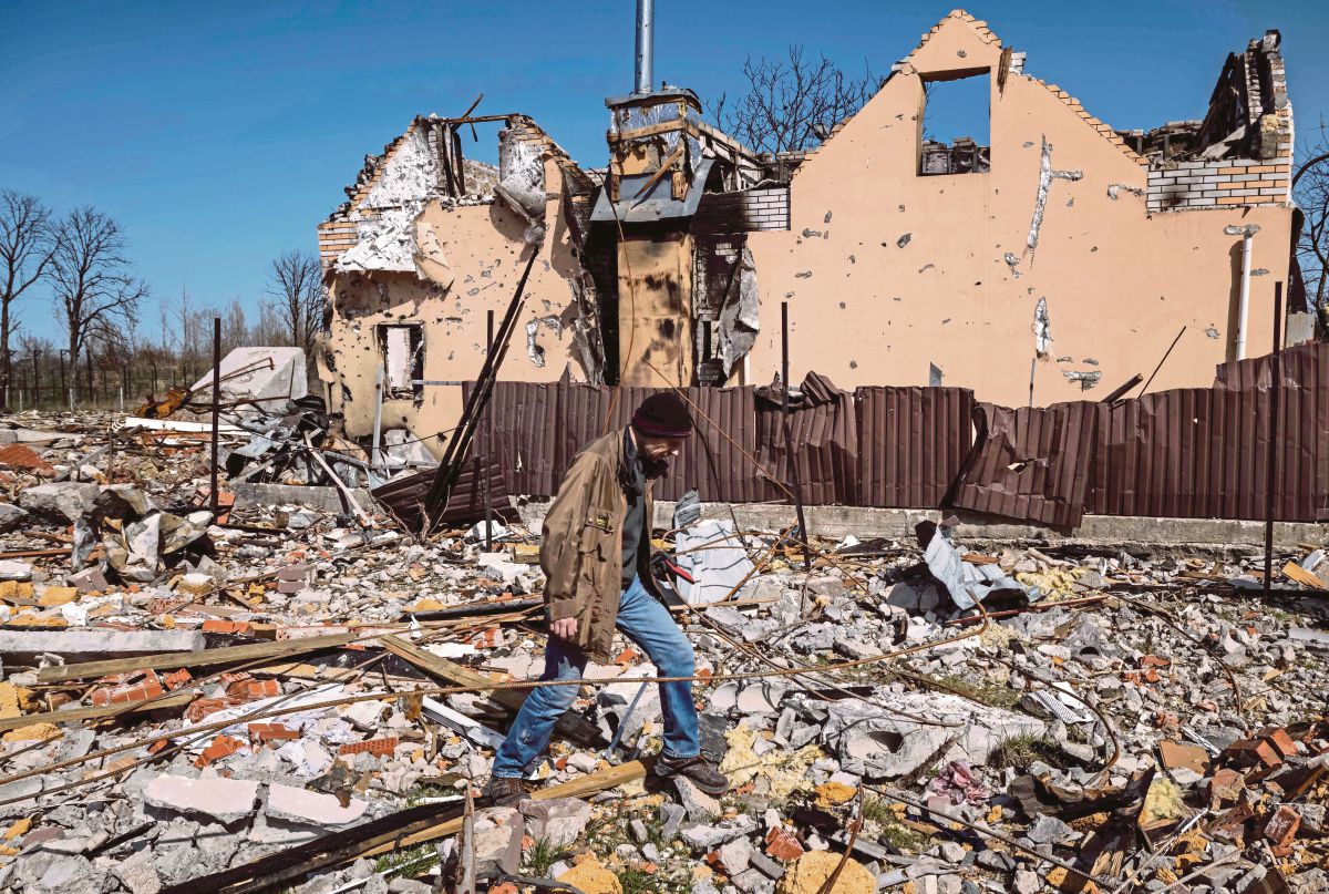 SEORANG lelaki berjalan melewati sebuah rumah yang musnah dibom di perkampungan Bohdanivka utara Kyiv, Ukraine.